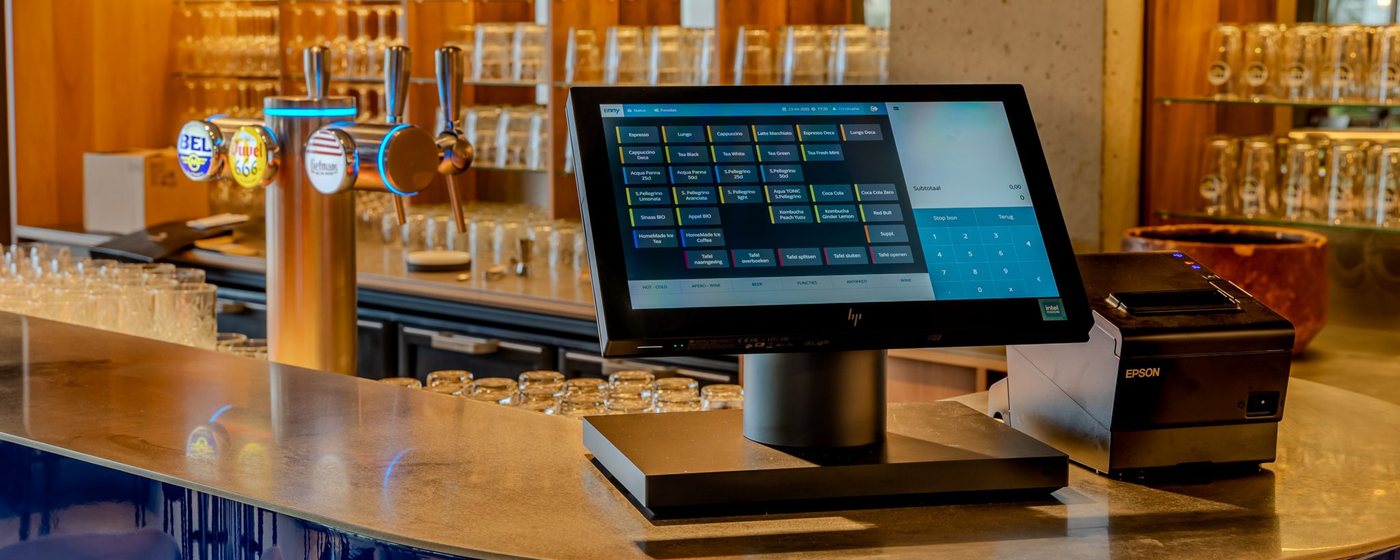 POS touchscreen and receipt printer on a bar counter, with beer taps behind
