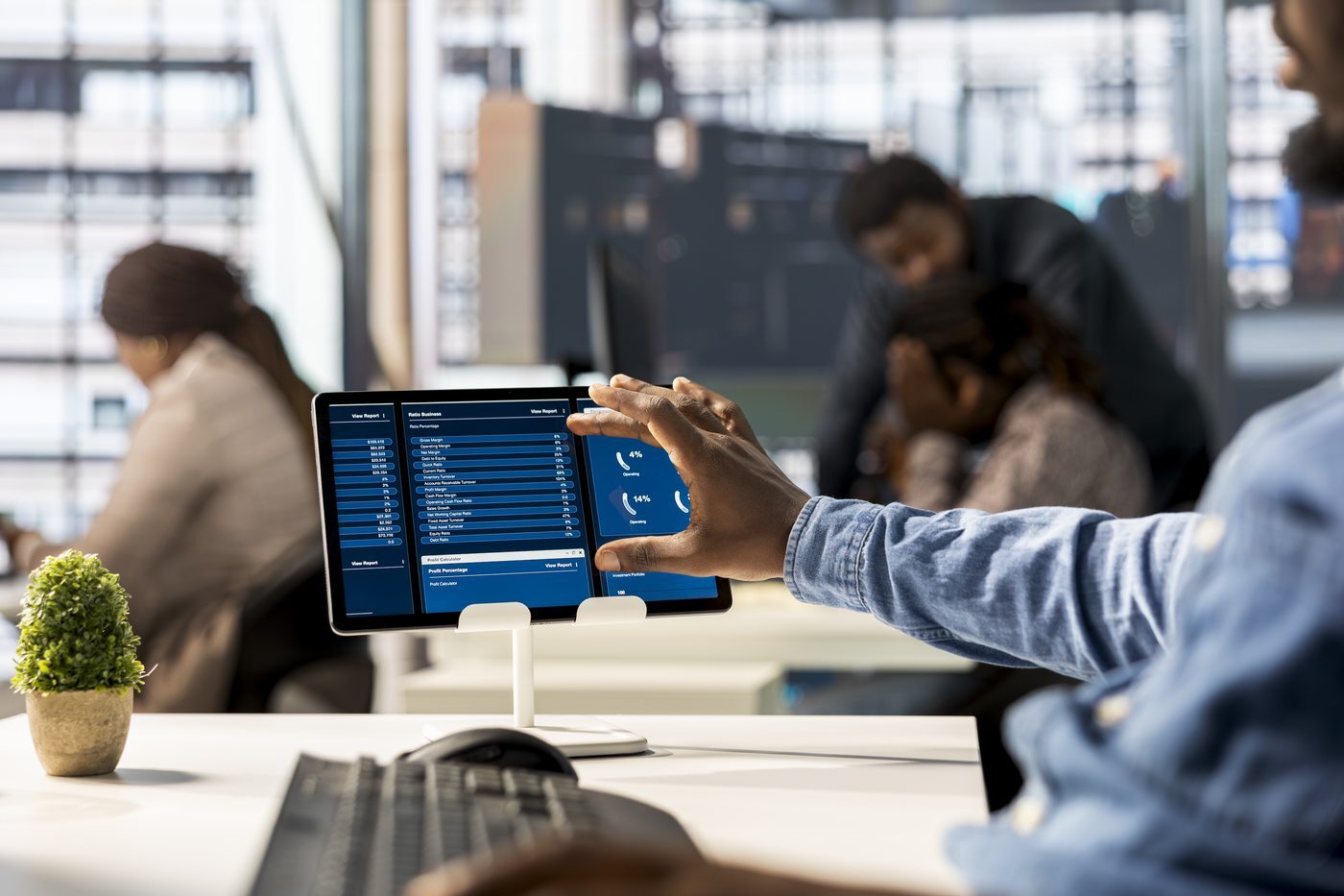 Persoon tikt op een financieel rapport op een tablet aan een bureau