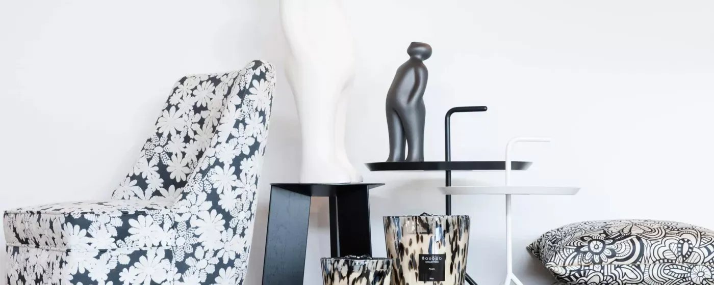 Home decor on side tables: a sculpture, a scented candle and patterned cushions